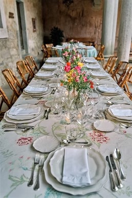 Mesa blanca con flores naranjas y rosadas en espacio interior elegante